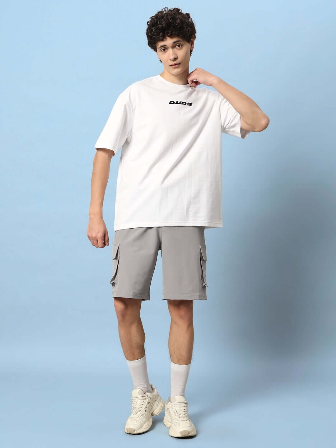 Model wearing Brawny Cargo Shorts in grey with white t-shirt and sneakers, emphasizing comfort and style for casual wear.