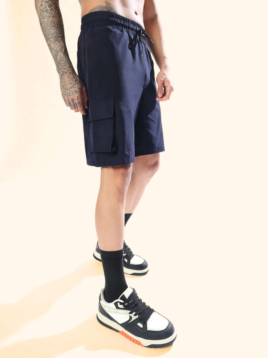 Model wearing navy blue Brawny cargo shorts, highlighting side pockets and casual fit, styled with sneakers on a neutral background.