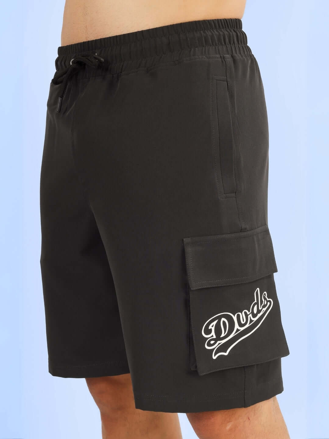 Dark grey Brawny cargo shorts with "Duds" logo, featuring a drawstring waist and large side pocket. Custom Fit available.