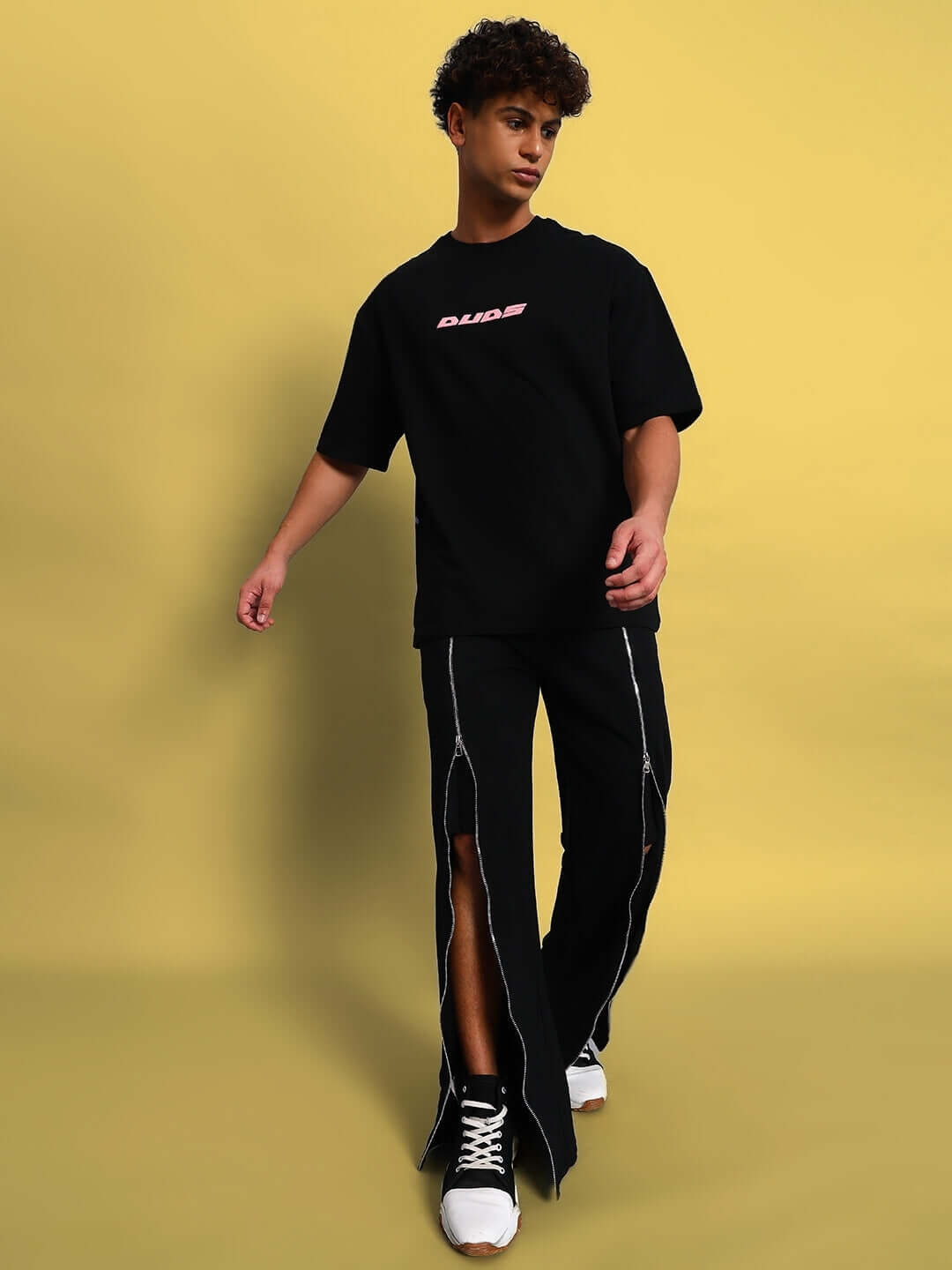 Model wearing BRAZO front open zipper joggers in black, paired with a DUDS t-shirt, showcasing custom fit option by DUDS Tailors.
