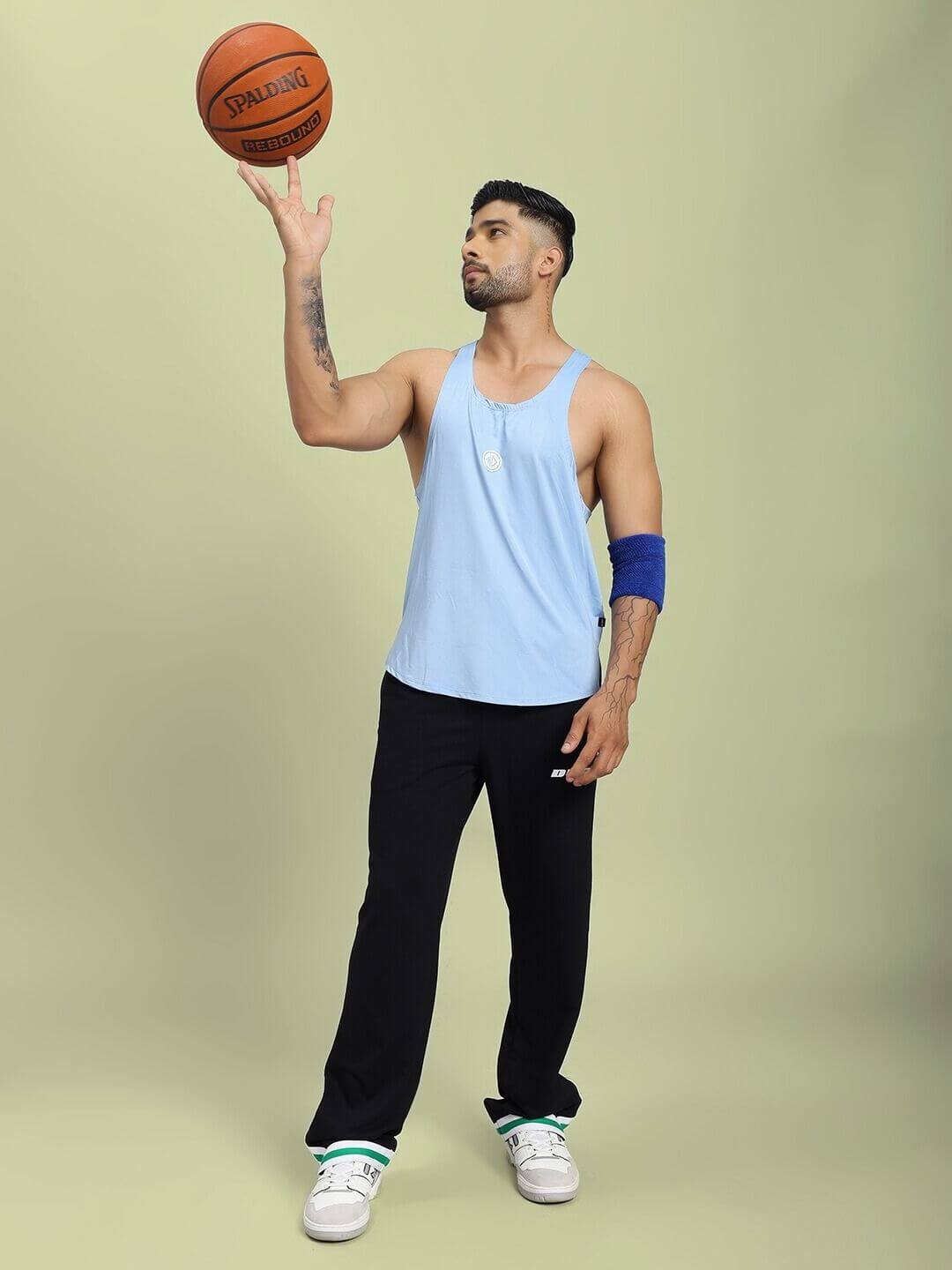 Man wearing BREEZE COMFORT GYM T-SHIRT LIGHT BLUE holding a basketball, showcasing comfort and style for active wear.