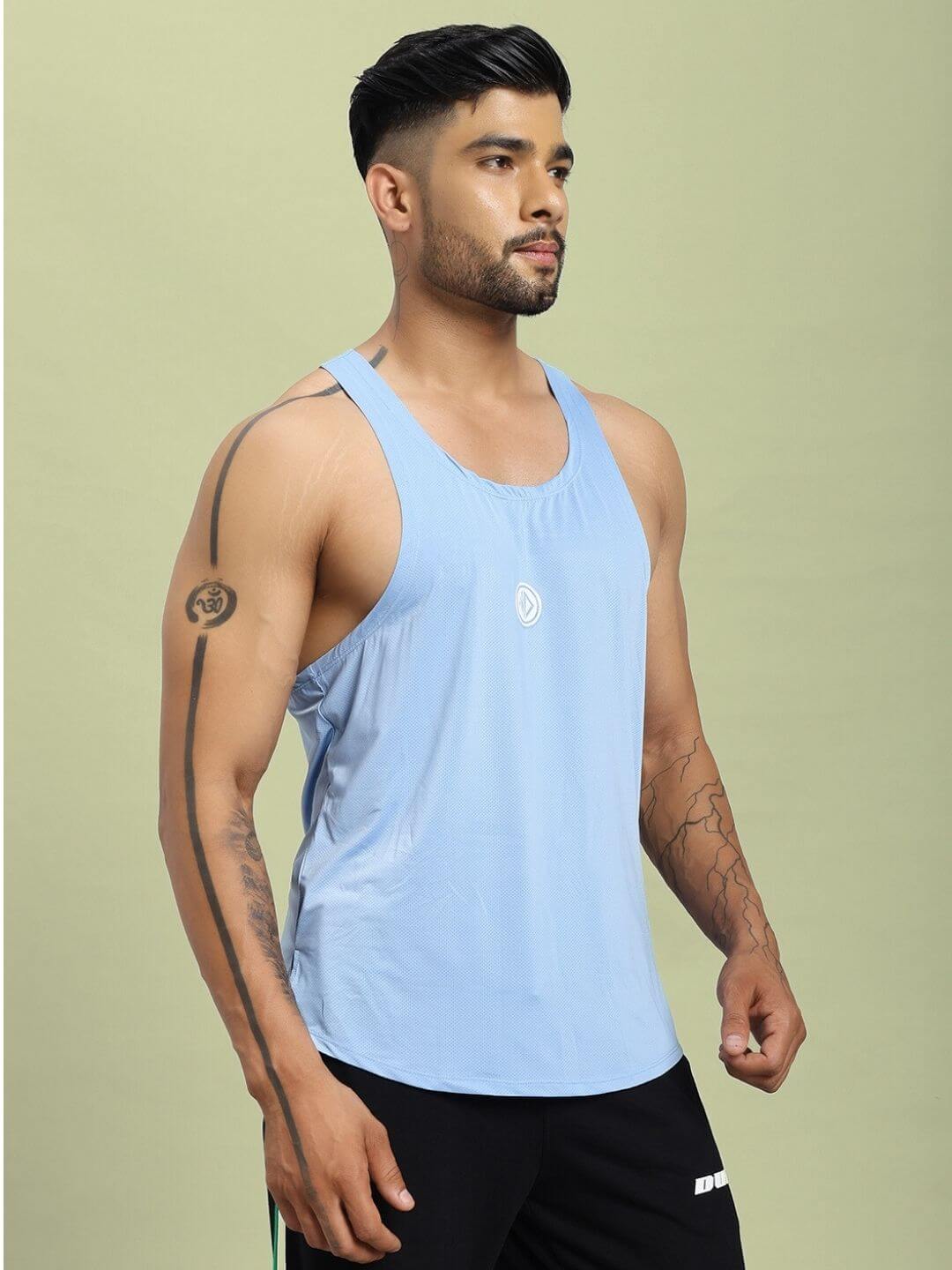 Man wearing BREEZE COMFORT GYM T-SHIRT LIGHT BLUE with tattoos and black shorts, highlighting soft, breathable, moisture-wicking fabric.
