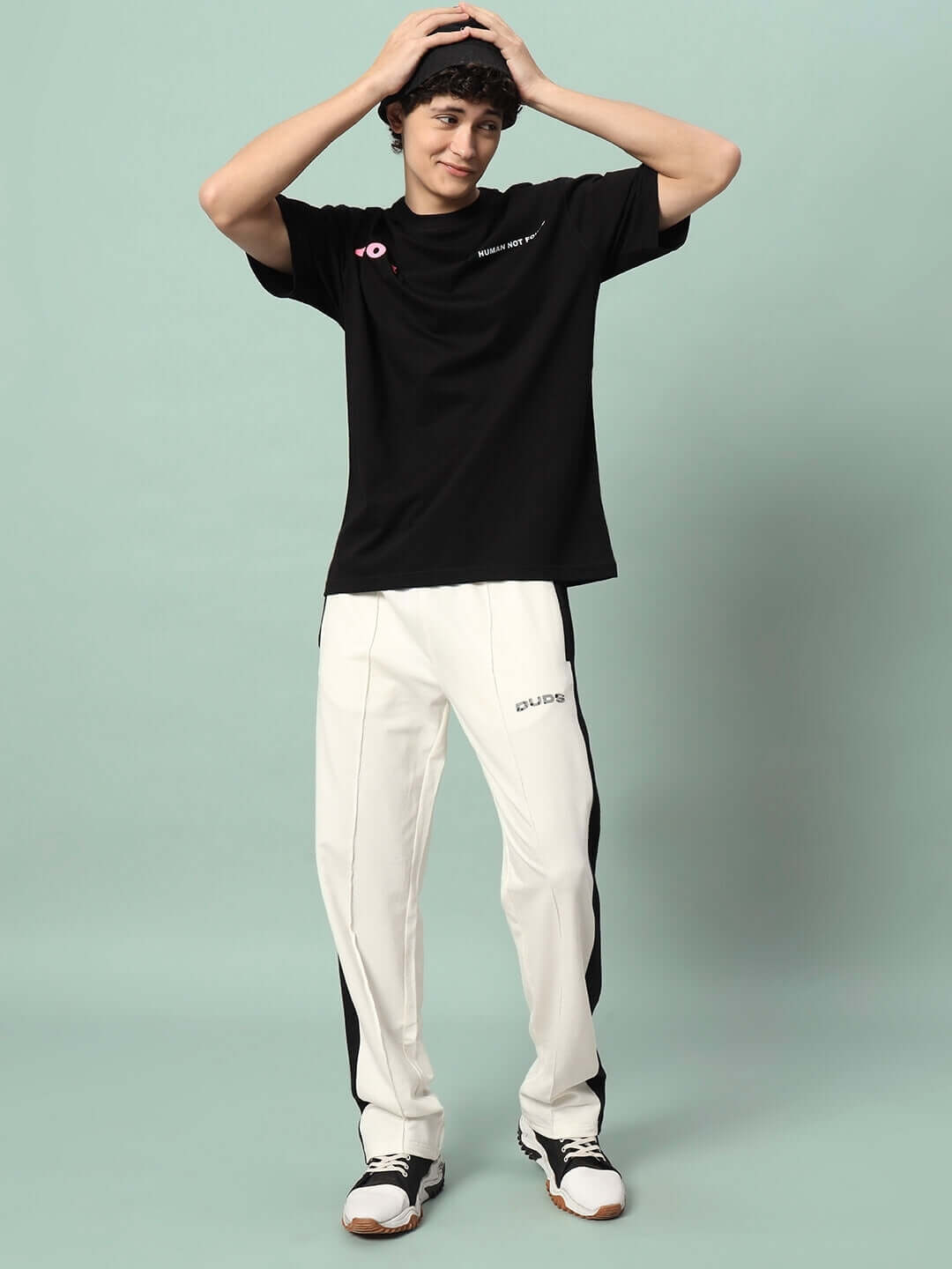 Model wearing BREEZER SIDE CONTRAST JOGGERS in off-white and black, made to order by DUDS with customizable fit options.