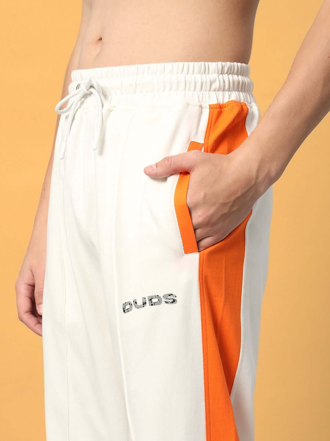 Close-up of Breezer Side Contrast Joggers in off-white and orange, featuring an elastic waistband and pocket details.