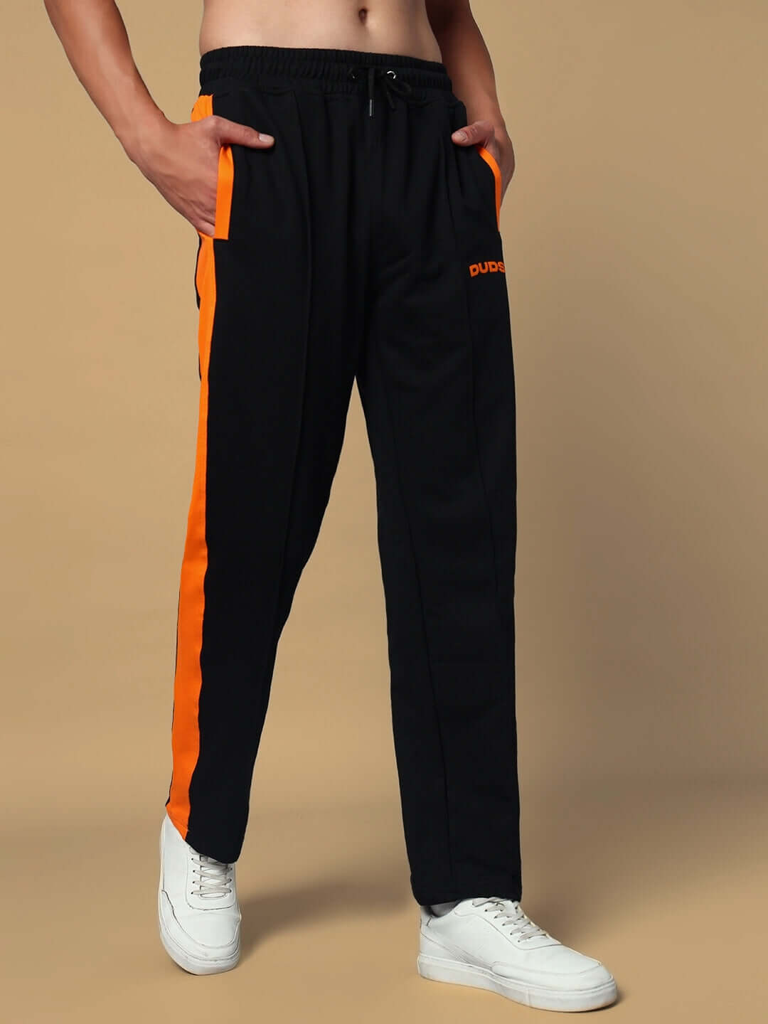 Man wearing black joggers with orange side contrast, featuring elastic waistband, from DUDS. Custom fit options available.