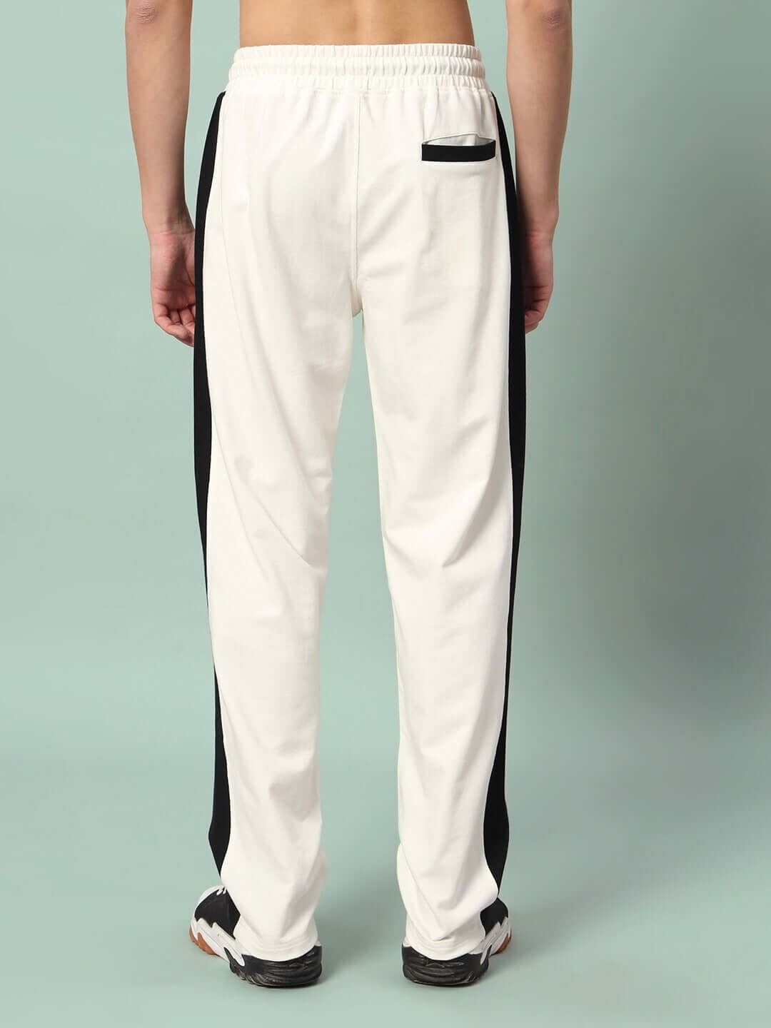 Rear view of off-white joggers with black side contrast detailing, showcasing comfortable elastic waistband and back pocket design.