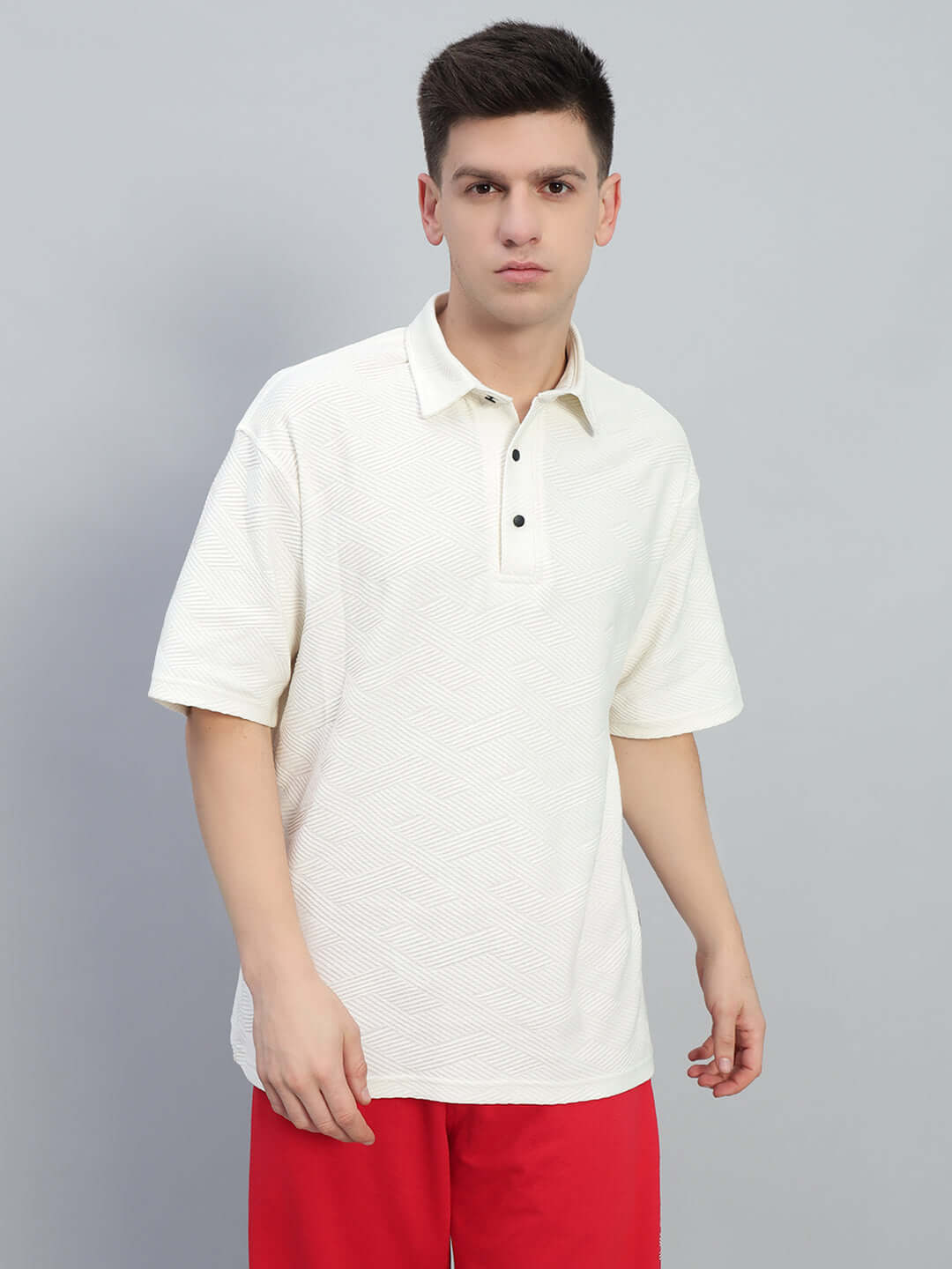 Man wearing BROCADE POLO COTTON T-SHIRT OFF WHITE with red pants, showcasing textured cotton fabric.