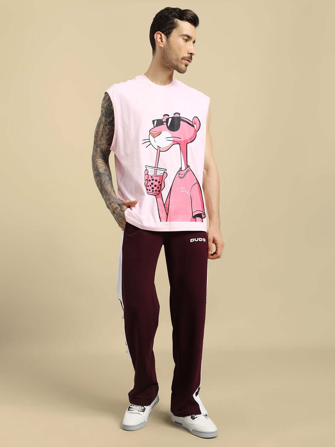 Man wearing BROX STAR maroon-white relaxed fit joggers paired with a sleeveless pink graphic shirt, posing against a neutral background.