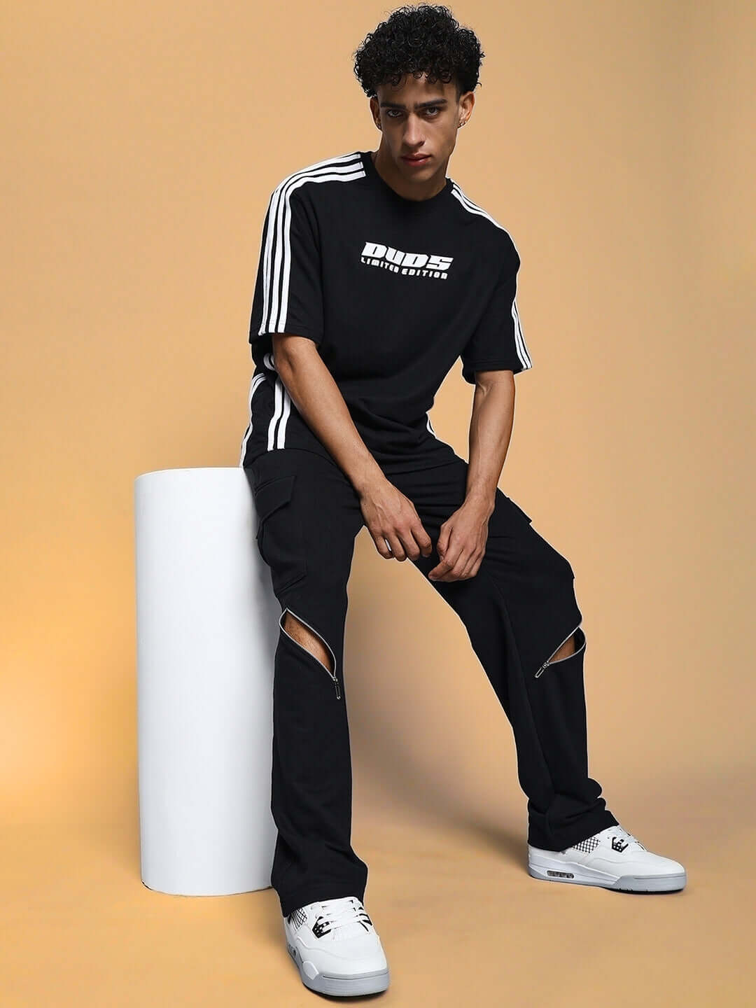 Model wearing BRUNO 5 Pocket Cargo Pants in Black with sporty DUDS t-shirt, showcasing casual and customizable fashion.