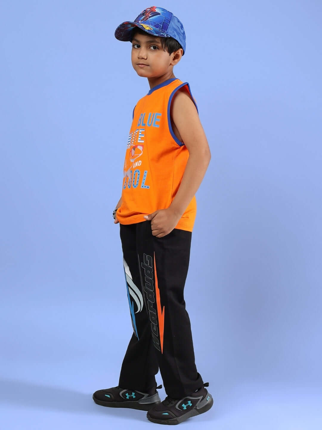 Child wearing BUFFY CO-ORD FOR BOYS & GIRLS ORANGE BLACK outfit, featuring an orange top and black pants with blue accents.
