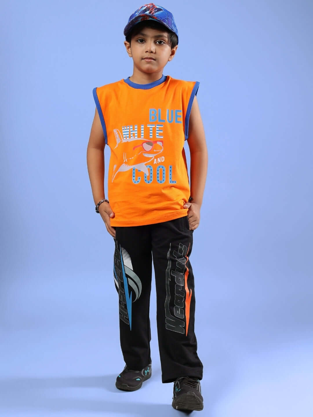 Child wearing BUFFY CO-ORD FOR BOYS & GIRLS ORANGE BLACK outfit, featuring orange sleeveless top and black pants with playful design.