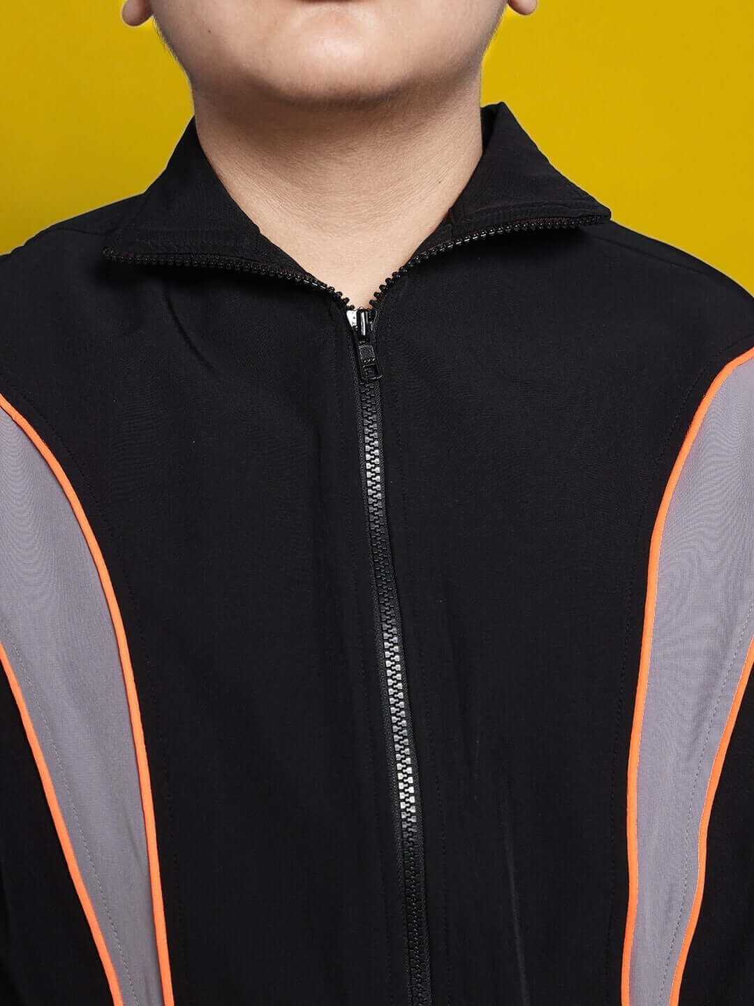 Black bullet parachute jacket for boys and girls with orange accents, available for custom fit. Stylish design for kids from DUDS.