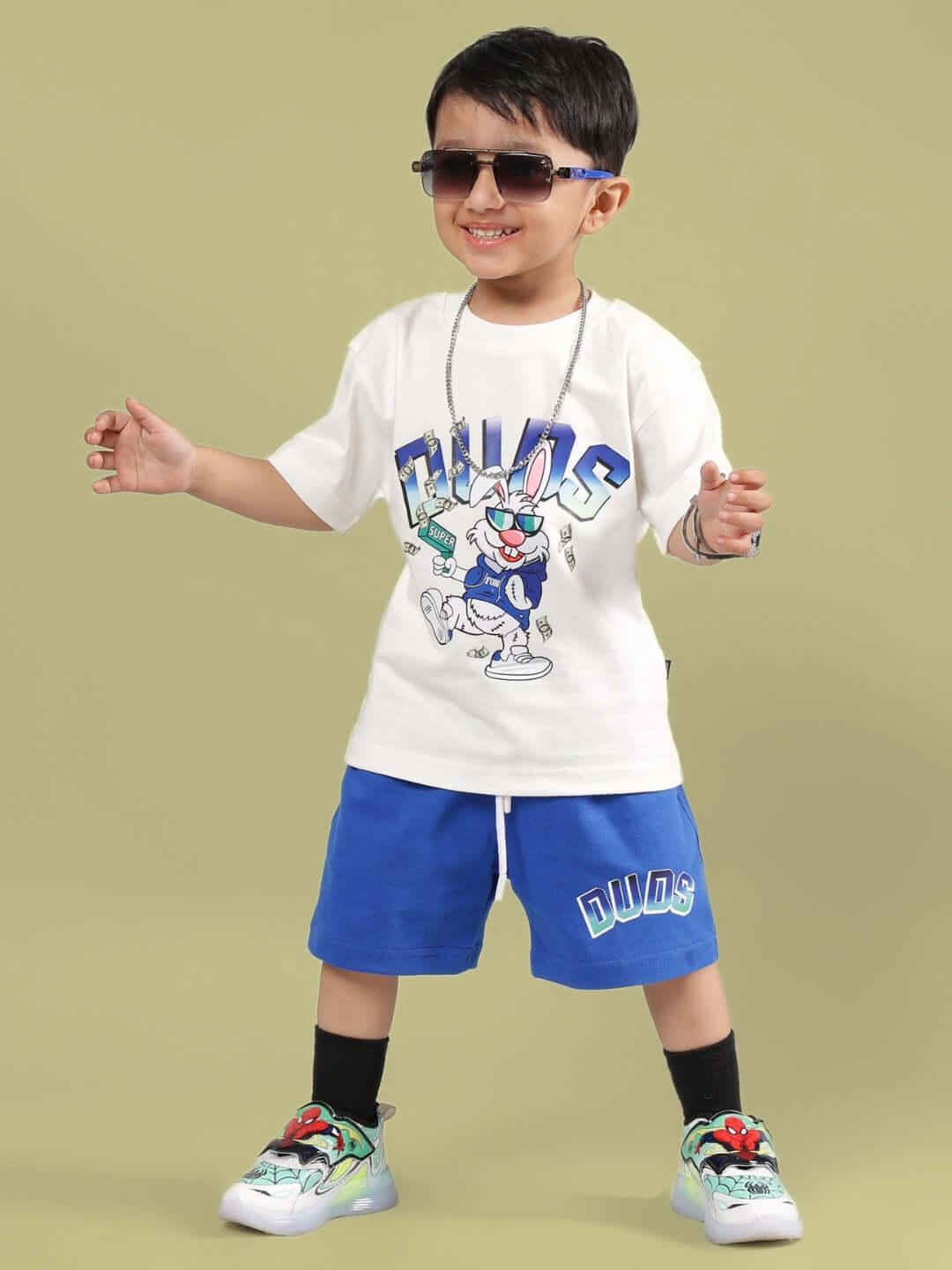 Child wearing BUMBLE CO-ORD FOR BOYS & GIRLS OFF WHITE-R BLUE, featuring cartoon graphics, DUDS branding, and stylish sneakers.