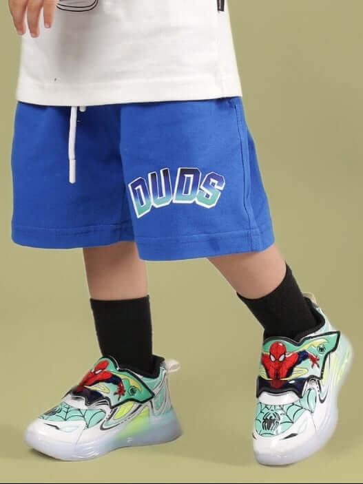Child wearing BUMBLE SHORTS FOR BOYS & GIRLS ROYAL BLUE by Duds with colorful sneakers.