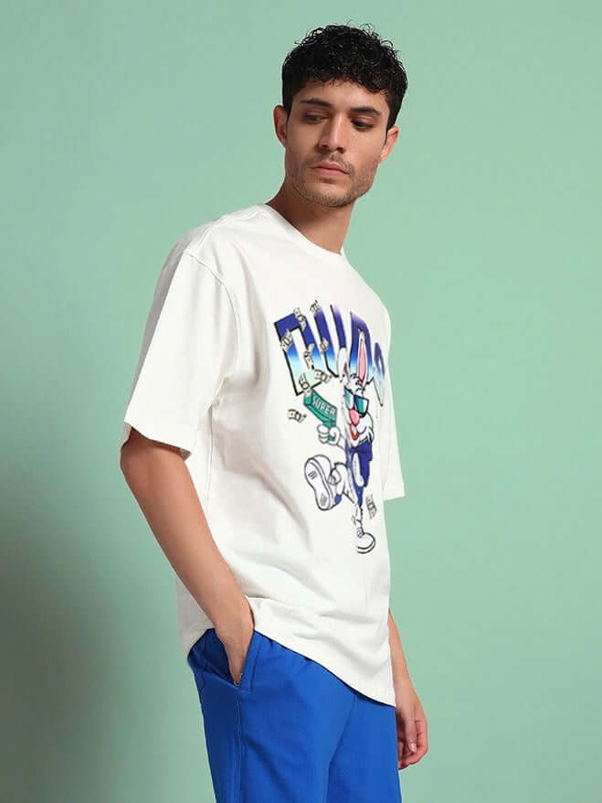 Model wearing BUNNY BUGS OVERSIZED T-SHIRT OFF-WHITE, a trendy summer tee paired with blue shorts, perfect for casual looks.