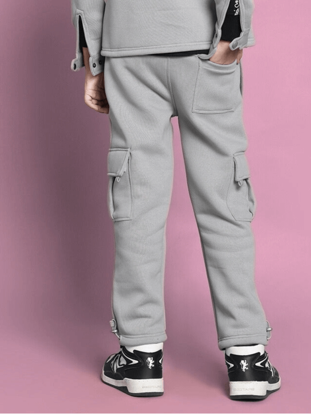 Back view of a child wearing grey Burly Fleece Pants, showcasing cargo pockets and stylish design, suitable for boys and girls.