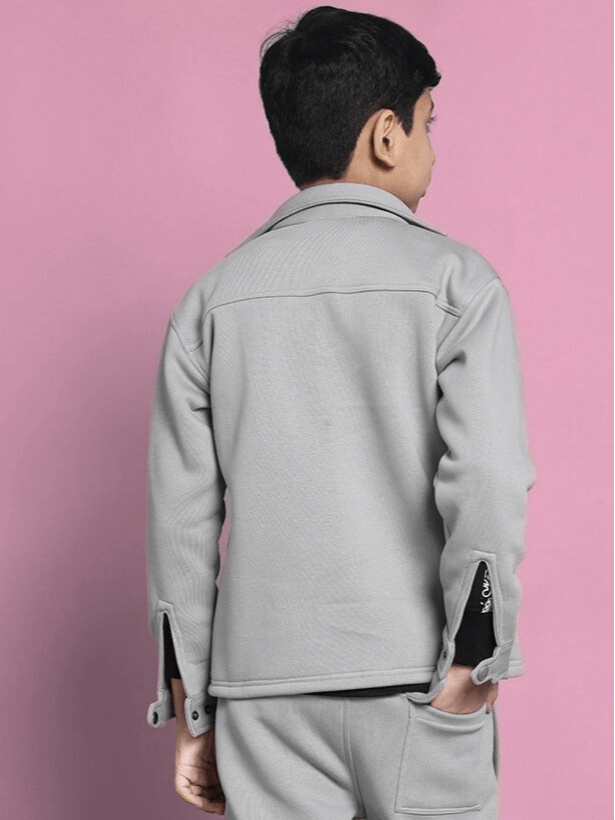Boy wearing Burly fleece sweatshirt in grey, back view, against a pink background