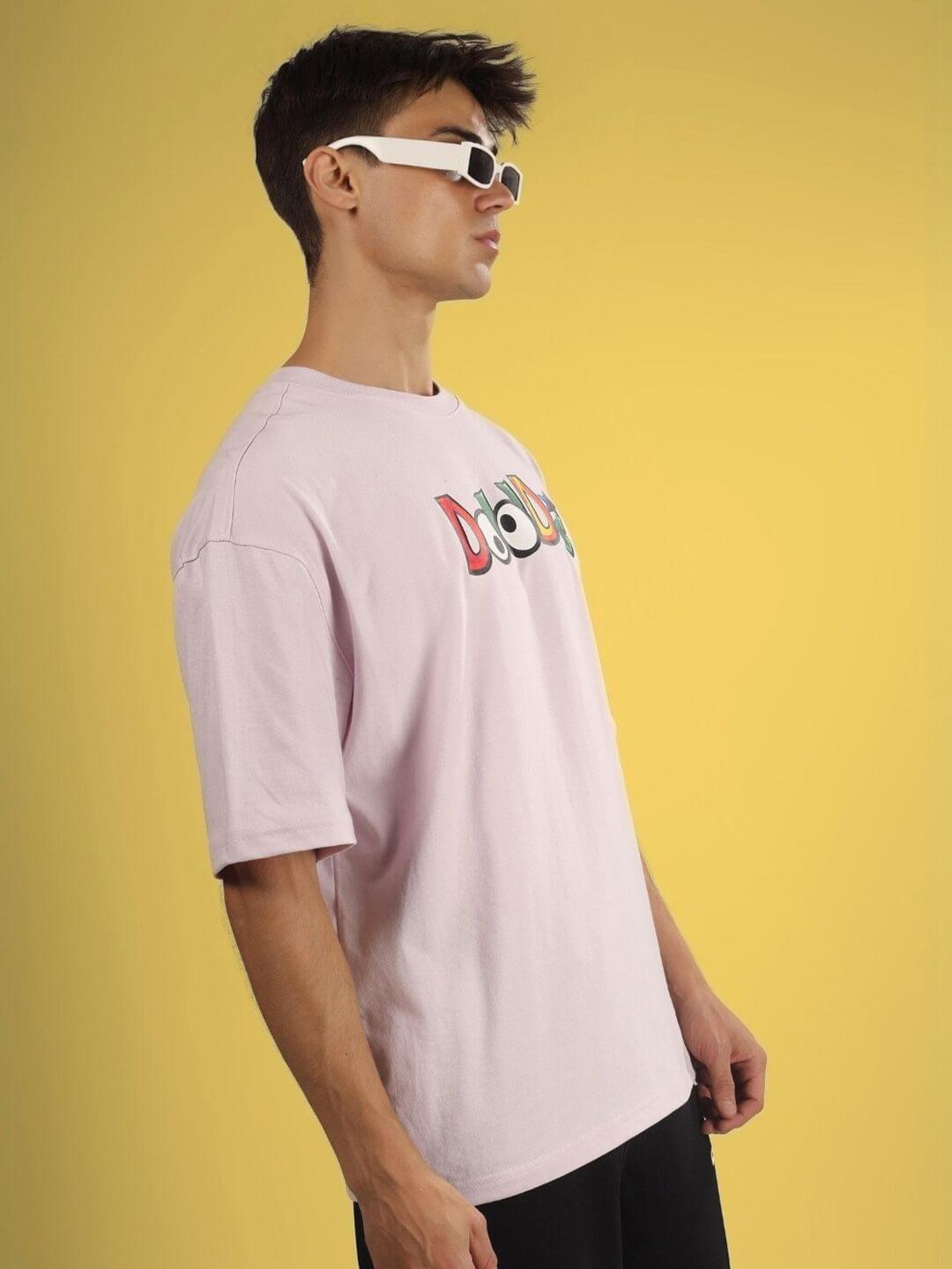 Man wearing DUDS MONSTER OVER-SIZED T-SHIRT PALE PINK with logo, 100% cotton, premium heavy gauge fabric, fashion look side profile