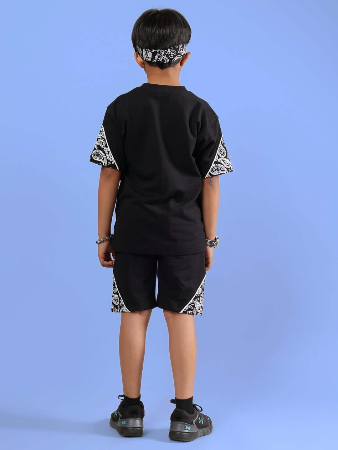 Child wearing CALVIN CO-ORD FOR BOYS & GIRLS BLACK, featuring a stylish black t-shirt and shorts set with patterned sleeves and hem, back view.