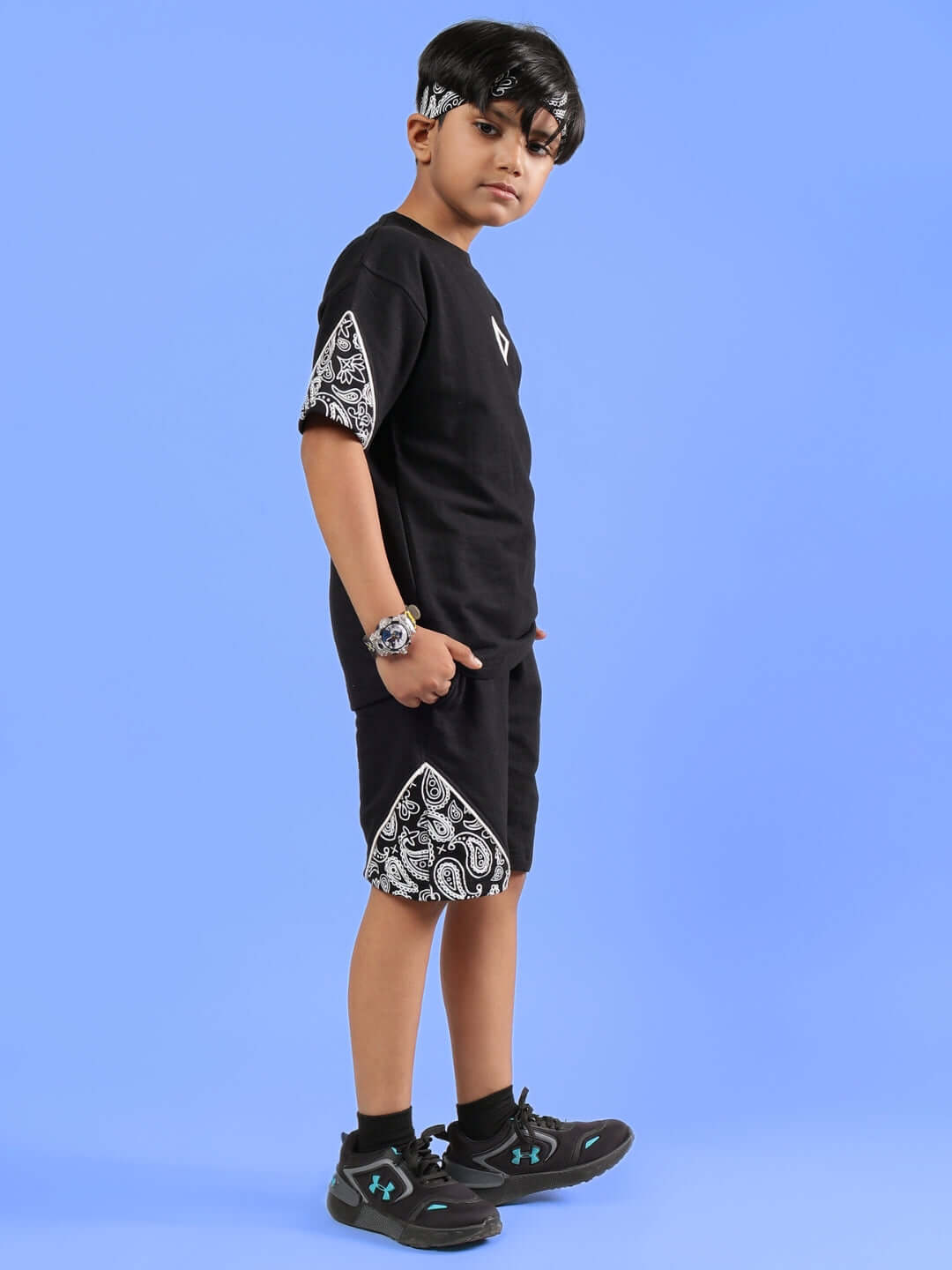 Child wearing CALVIN CO-ORD FOR BOYS & GIRLS BLACK set against a blue background, showcasing stylish design and comfort for kids.