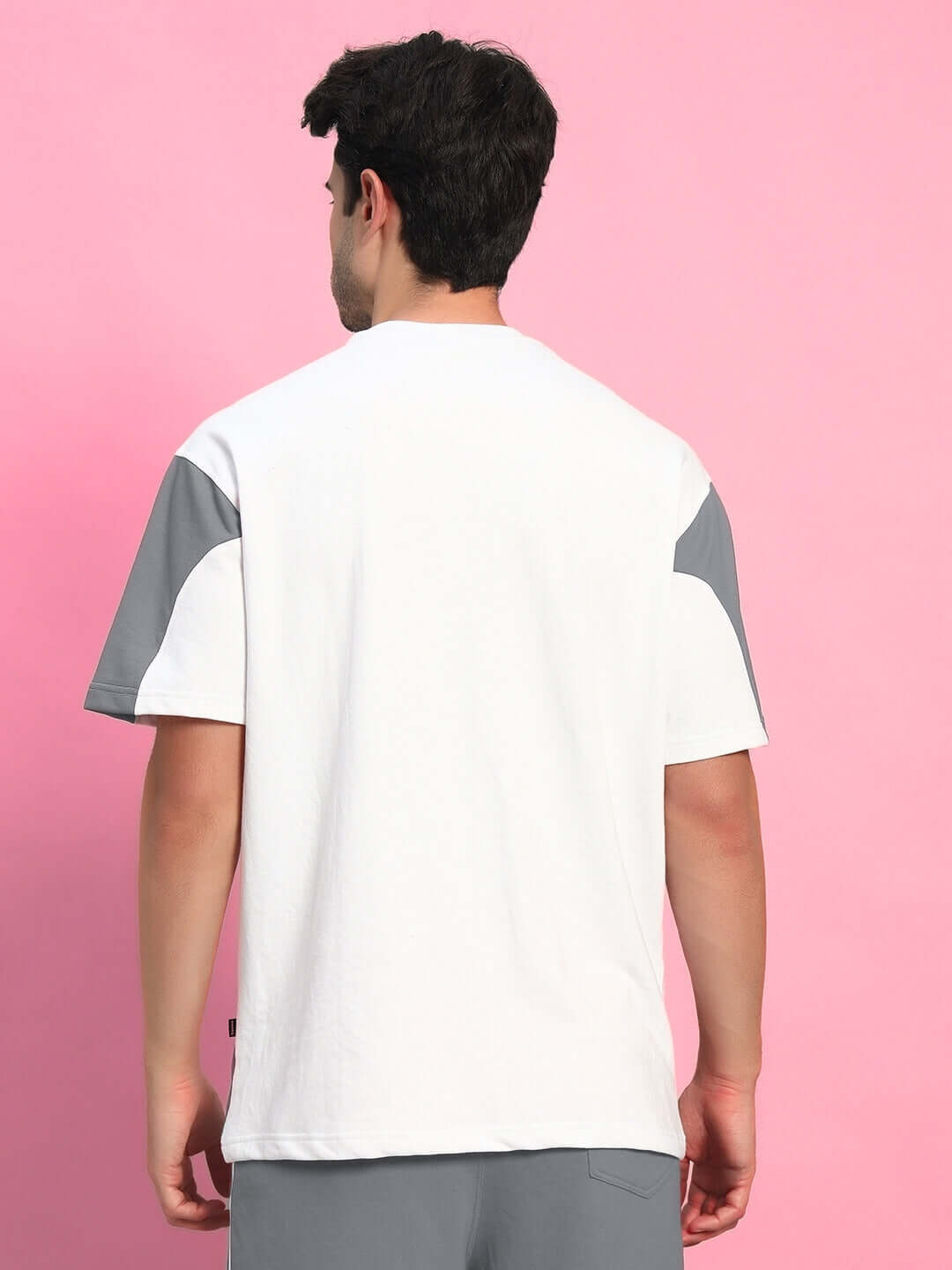 Back view of Candor oversized T-shirt in white and grey, made from premium cotton French terry and elastane, worn by a male model.
