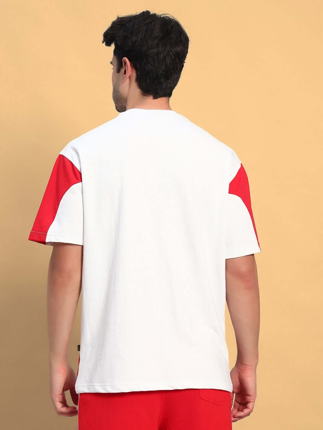 Back view of CANDOR OVER-SIZED T-SHIRT WHITE RED with red accents, highlighting modern streetwear style.