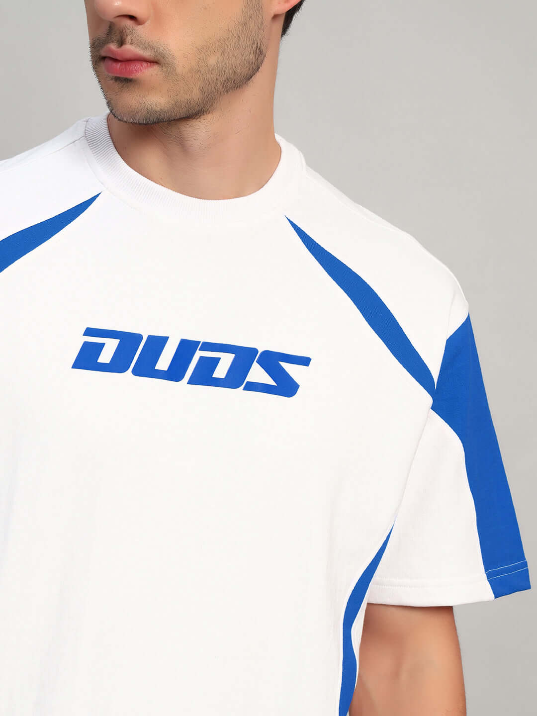 Model wearing CANDOR OVER-SIZED T-SHIRT WHITE BLUE with streetwear style and bold blue accents.