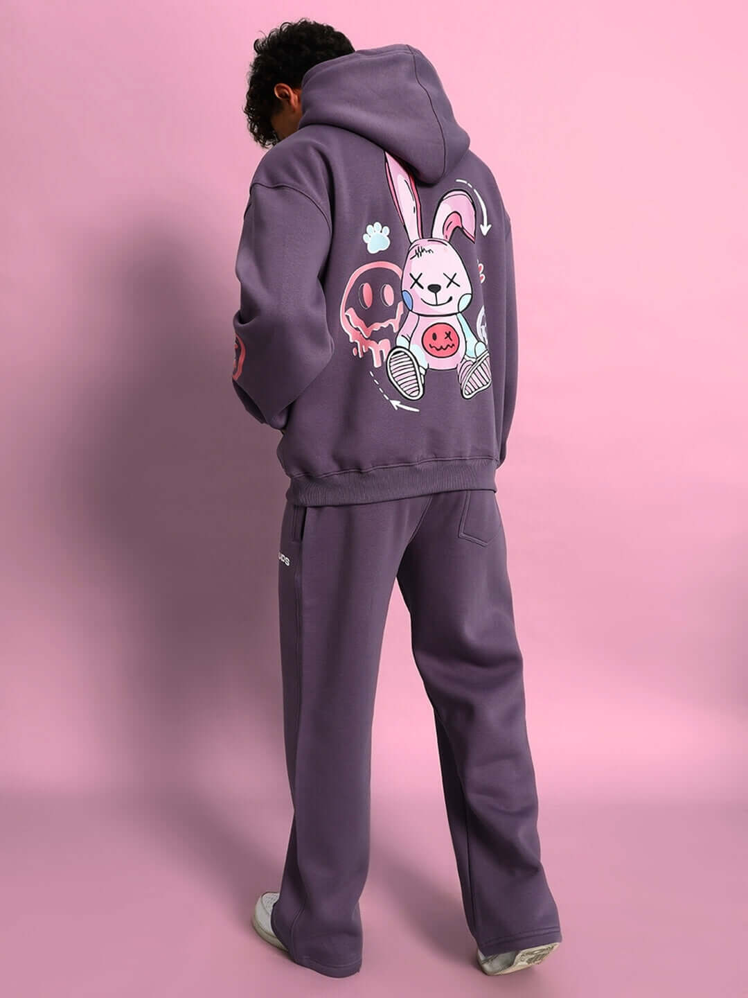 Man wearing CASPER COTTON FLEECE CO-ORD VIOLET hoodie and joggers, featuring playful graphic design.