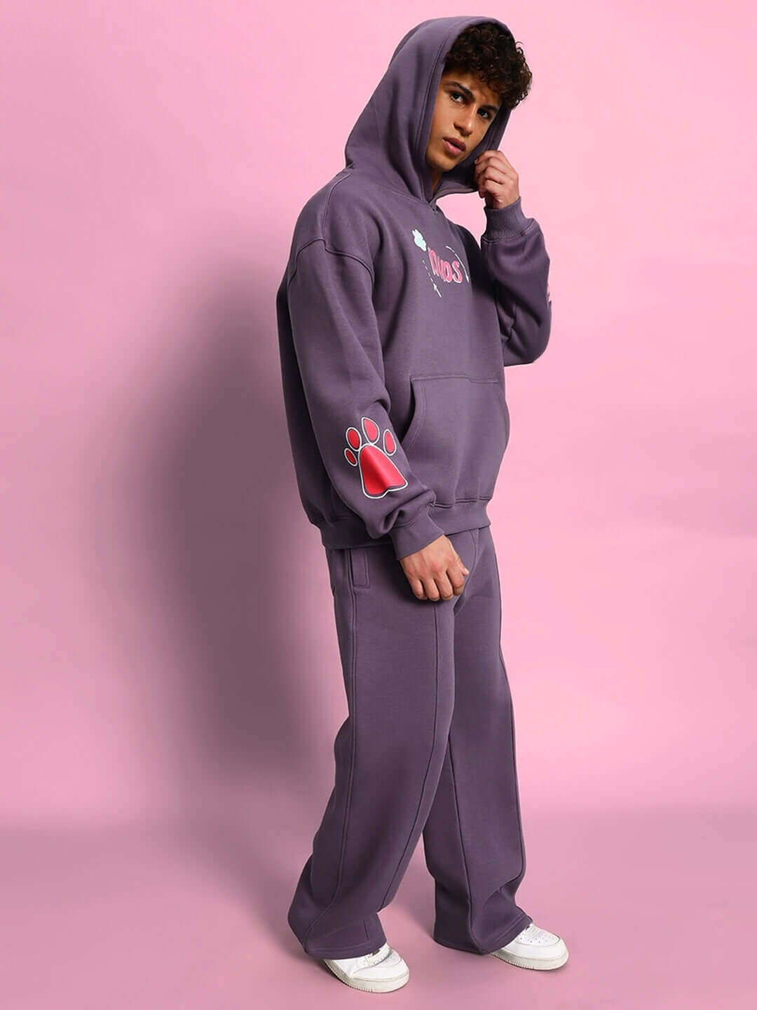 Model wearing CASPER COTTON FLEECE CO-ORD VIOLET showcasing hoodie and joggers in a stylish modern streetwear look against pink background.