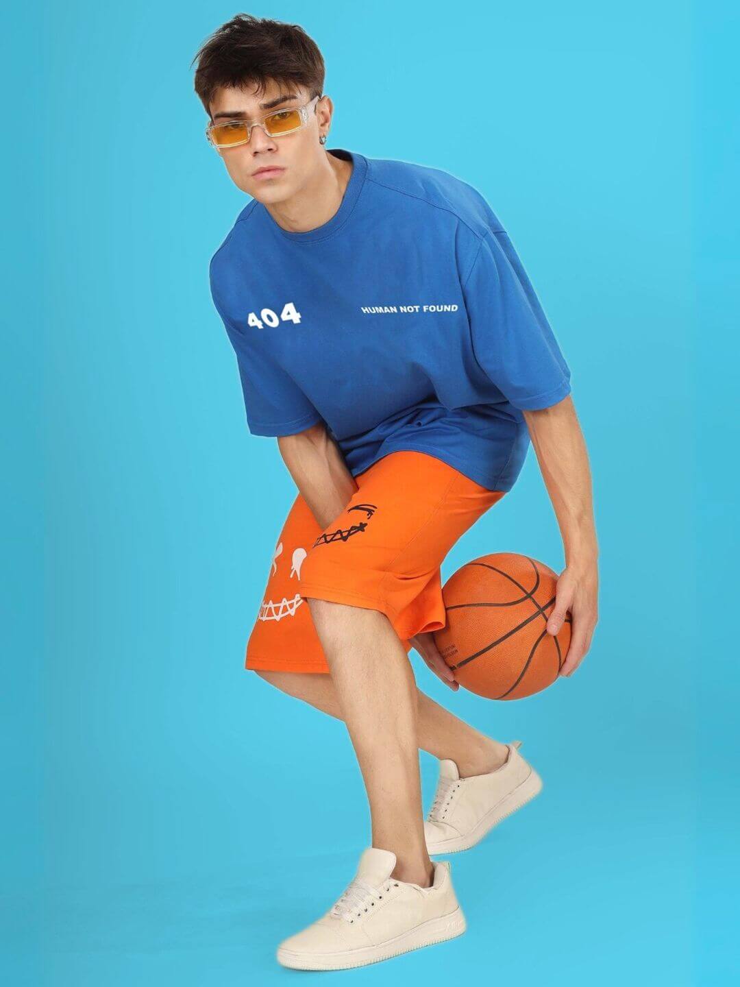 Man wearing 404 ERROR OVER-SIZED T-SHIRT ROYAL BLUE, playing basketball.