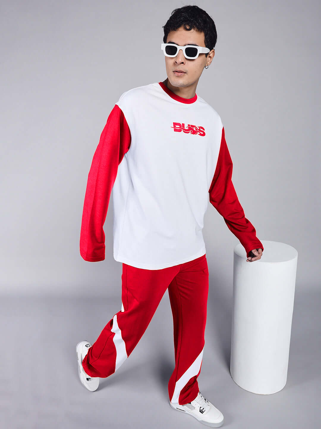 Model wearing CELESTINE COOL RELAXED FIT CO-ORD SET WHITE RED with bold red accents and matching sporty sunglasses.