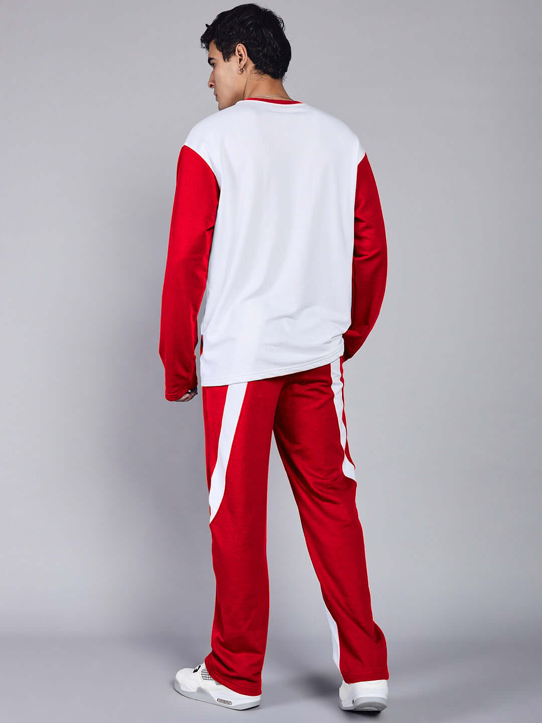 Man wearing CELESTINE COOL RELAXED FIT CO-ORD SET WHITE RED, showcasing bold streetwear style with red accents on a white base.