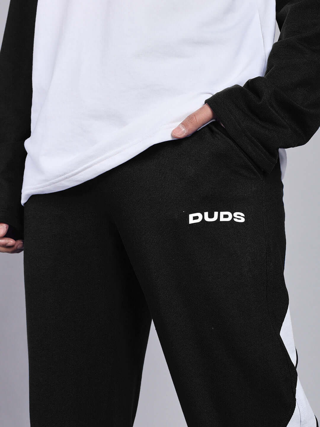 Close-up of CELESTINE COOL RELAXED FIT CO-ORD SET WHITE-BLACK with black pants featuring subtle branding detail.