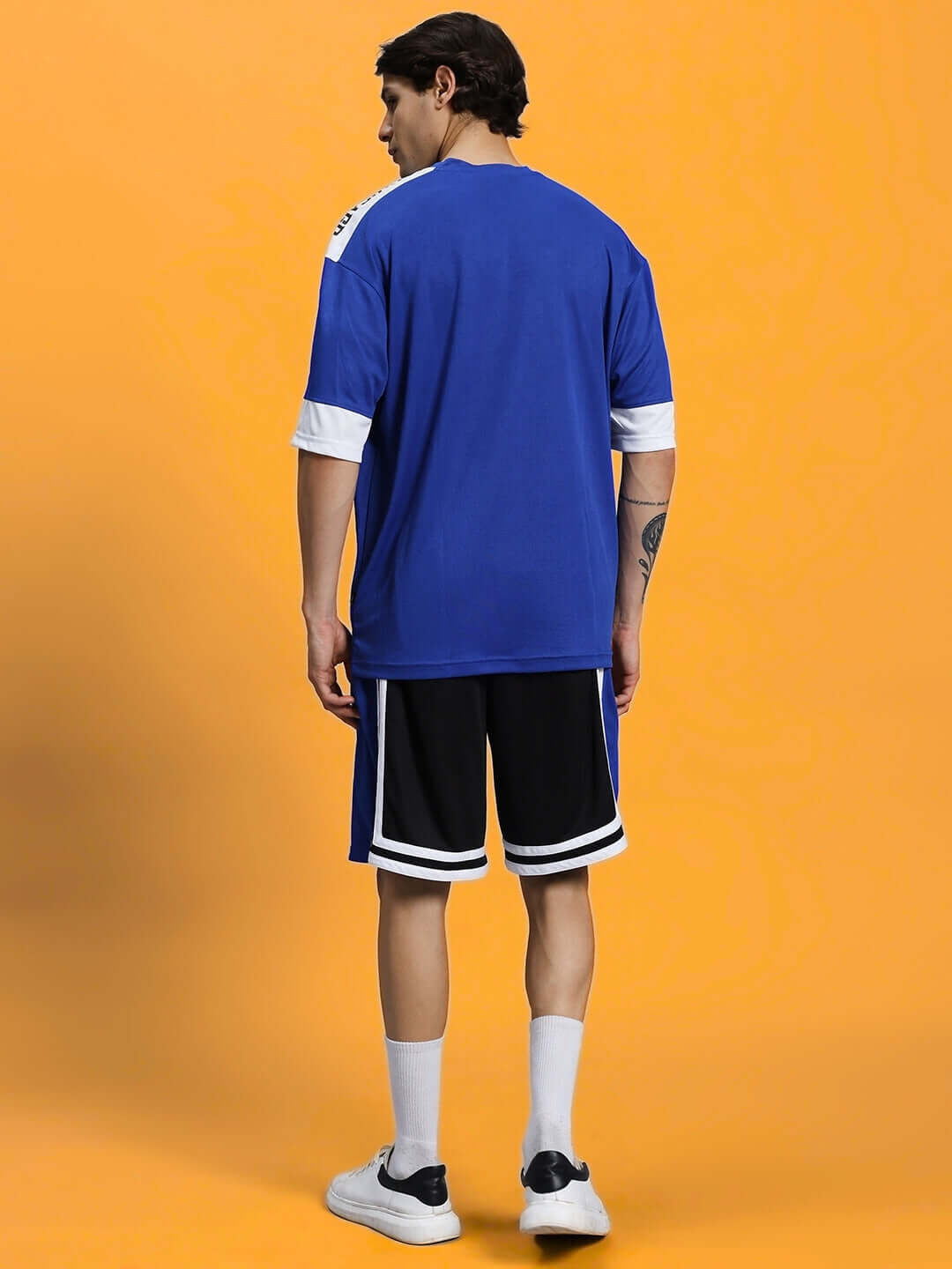 Rear view of a person wearing the CHALLENGE COLORBLOCK CO-ORD SET ROYAL BLUE, showcasing the vibrant colorblocking and relaxed fit.