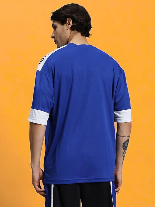 Rear view of model wearing CHALLENGE OVER-SIZED T-SHIRT ROYAL BLUE, showcasing relaxed fit and vibrant royal blue color.