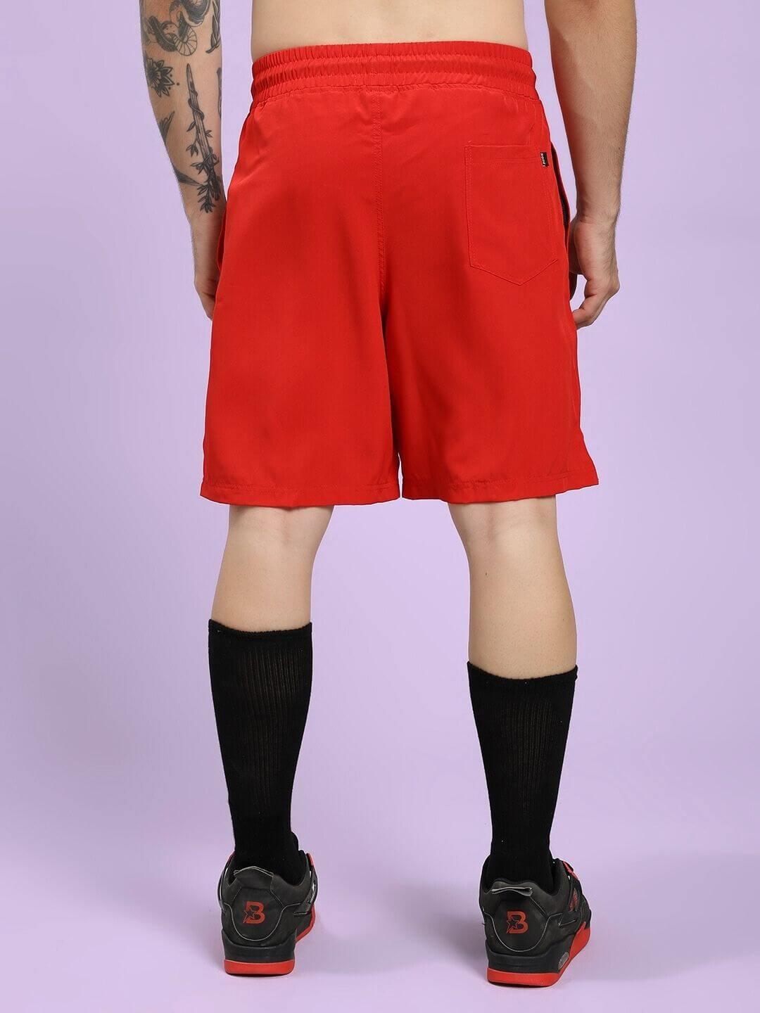 Back view of CHAMPION ZONE FRONT PLATED SHORTS RED worn by male athlete, showcasing bold style and breathable fabric for active wear.