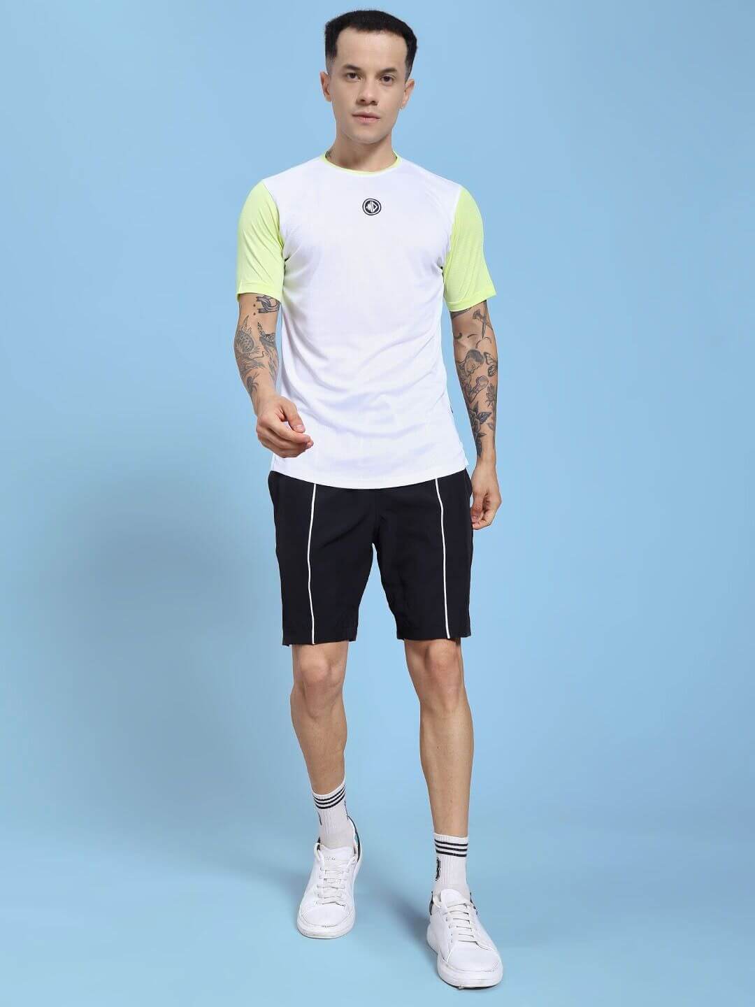 Man wearing CHAMPION ZONE REGULAR FIT CO-ORD SET WHITE NEON BLACK against blue background.