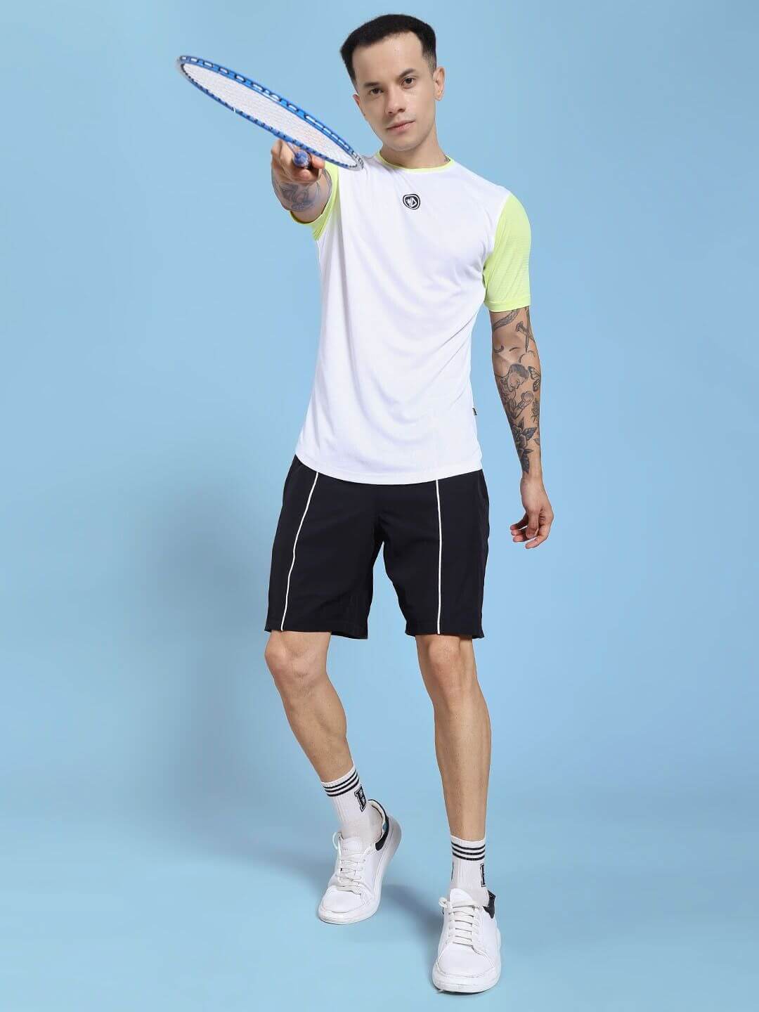 Man wearing CHAMPION ZONE REGULAR FIT CO-ORD SET WHITE NEON BLACK holding a tennis racket.