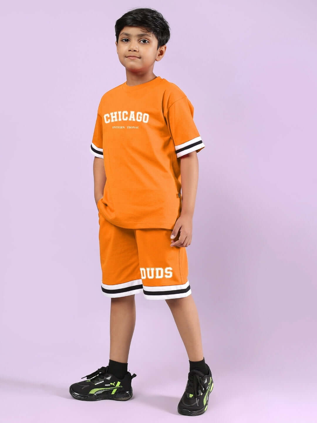 CHICAGO PRINTED CO-ORD FOR BOYS & GIRLS ORANGE outfit featuring sporty design, modeled by child on a purple background, perfect for casual wear.