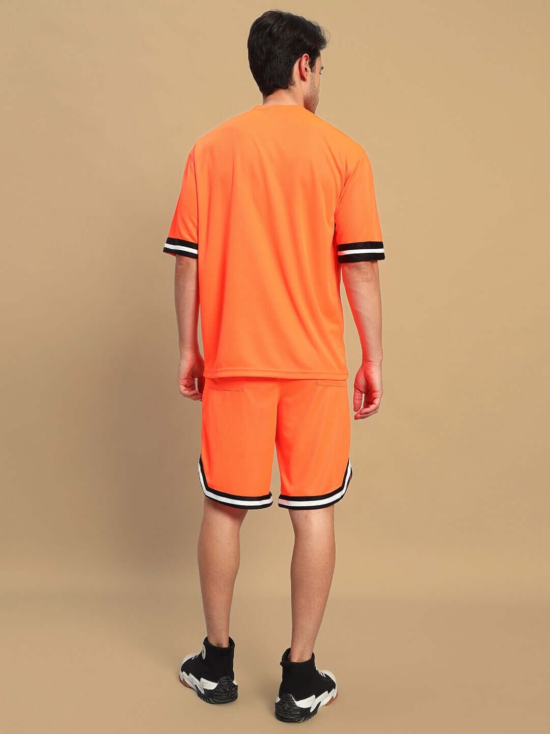 Back view of model wearing CHRONIC COLORBLOCK CO-ORD SET ORANGE with contrasting panels, perfect for bold streetwear style.