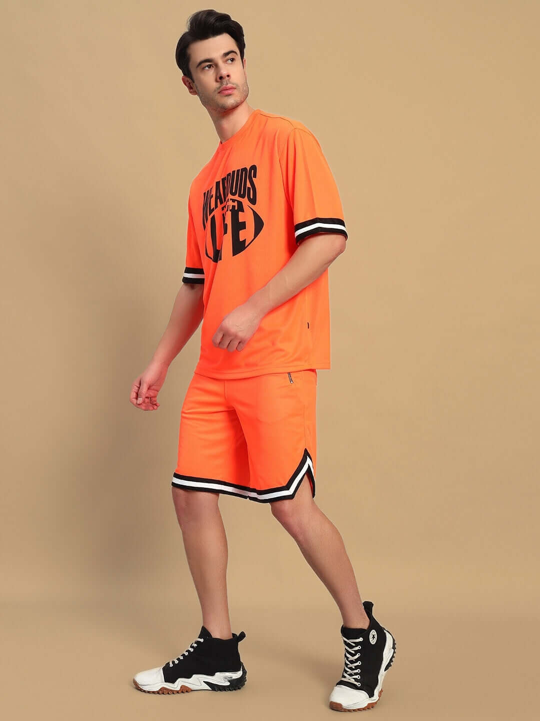 Model wearing CHRONIC COLORBLOCK CO-ORD SET ORANGE with striking colorblock design, paired with athletic shoes.