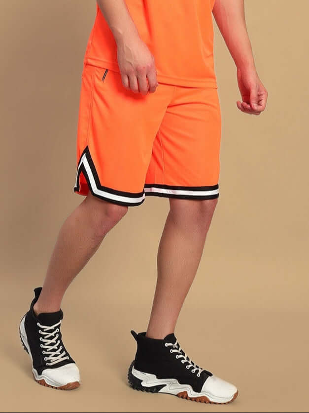 Person wearing CHRONIC REGULAR FIT SHORTS ORANGE with black sneakers, showcasing vibrant and comfortable design for kids.