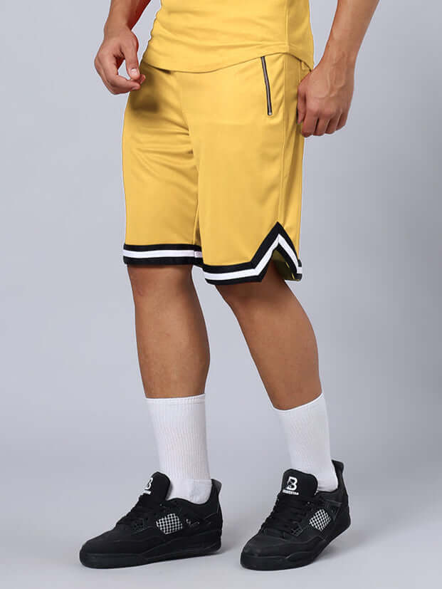 Person wearing CHRONIC REGULAR FIT SHORTS YELLOW with black sneakers and white socks.