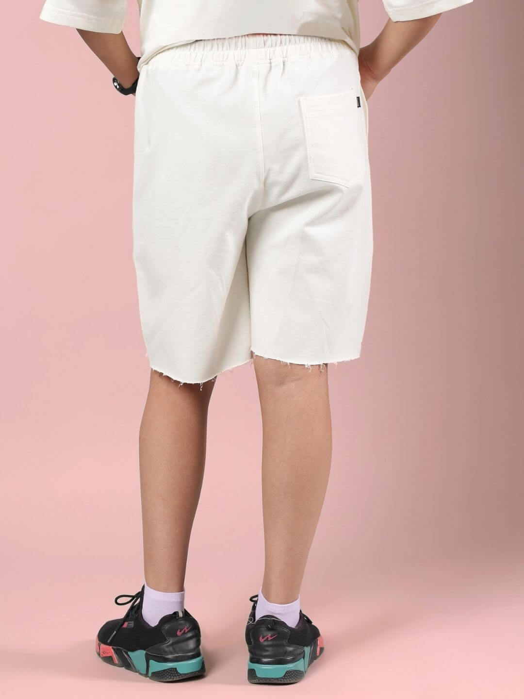 Back view of CLOUD PRINTED SHORTS FOR BOYS AND GIRLS OFF WHITE on model, showcasing off-white base and relaxed fit perfect for active kids.