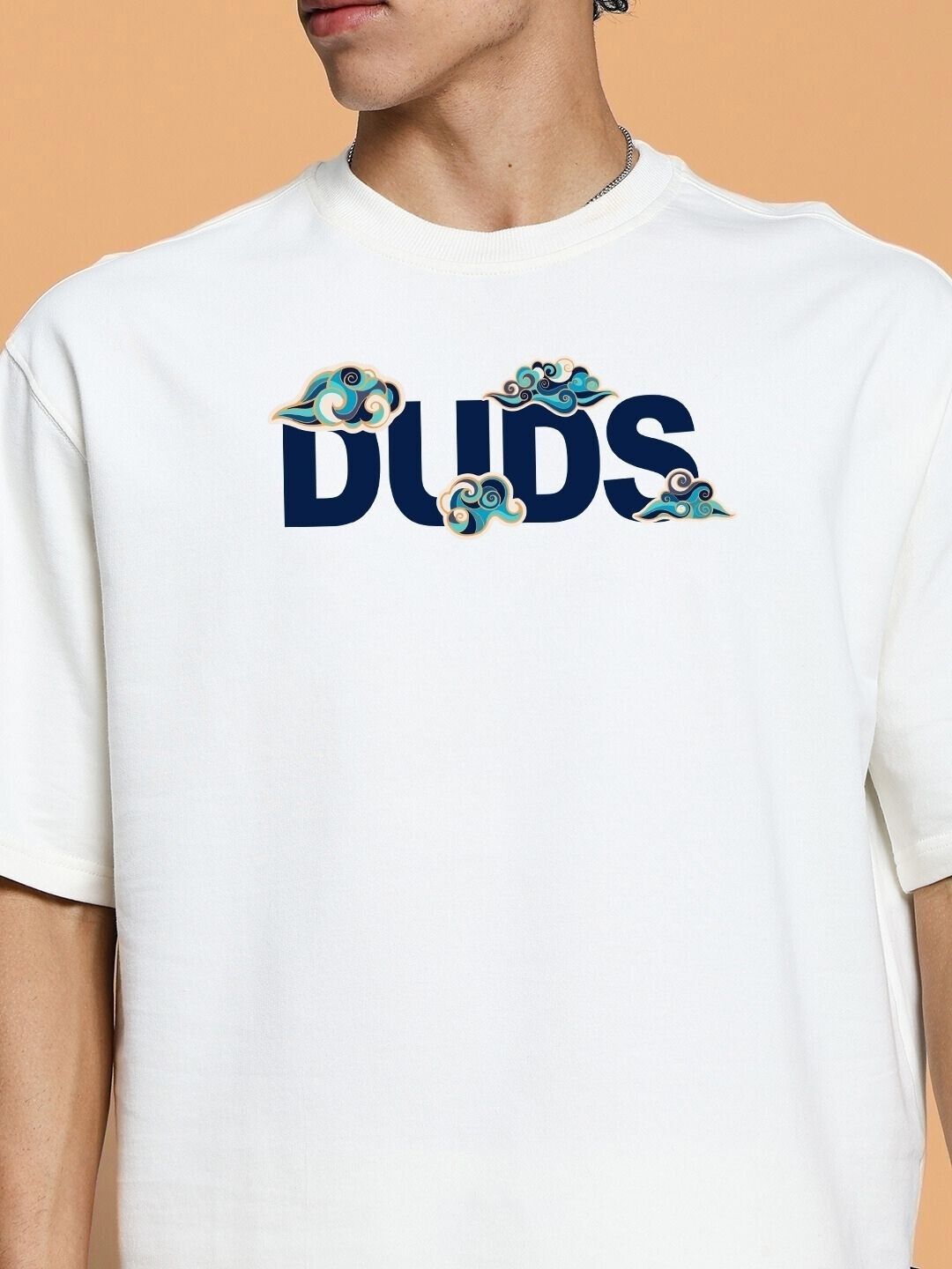 White t-shirt with 'DUDS' text and decorative design on the chest.