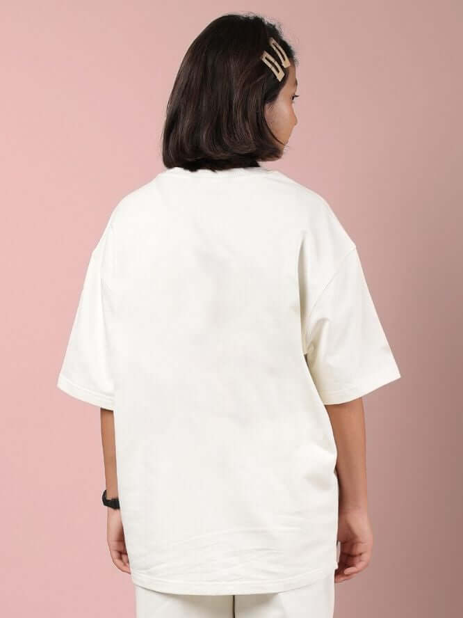 Child wearing CLOUD PRINTED OVERSIZED T-SHIRT FOR BOYS AND GIRLS OFF WHITE, showing back design on a pink backdrop.