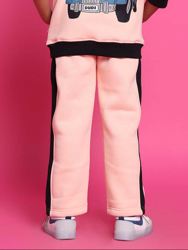 Child wearing Club House fleece joggers in black-beige, relaxed fit, perfect for play or school, showing back view with sneakers.