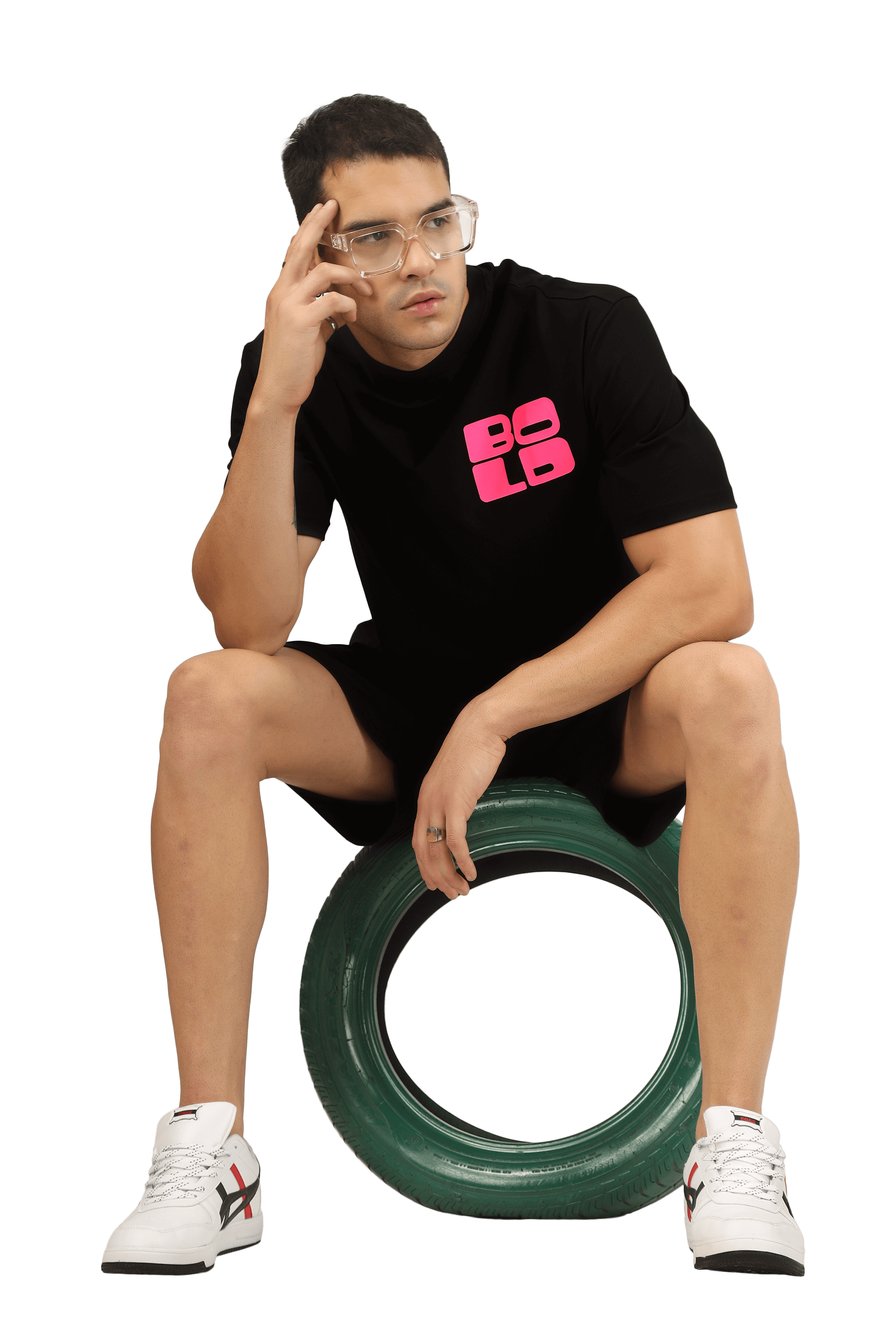 Model wearing a CO-ORD SET WITH PRINT in bold design, seated on a green tire, highlighting trendy urban style.