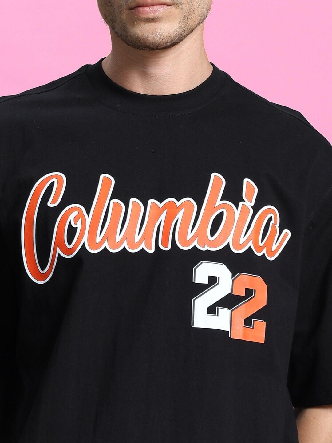 COLUMBIA 22 PRINT SUMMER CO-ORD SET BLACK RED t-shirt with bold graphics on a pink background, showcasing urban street style.