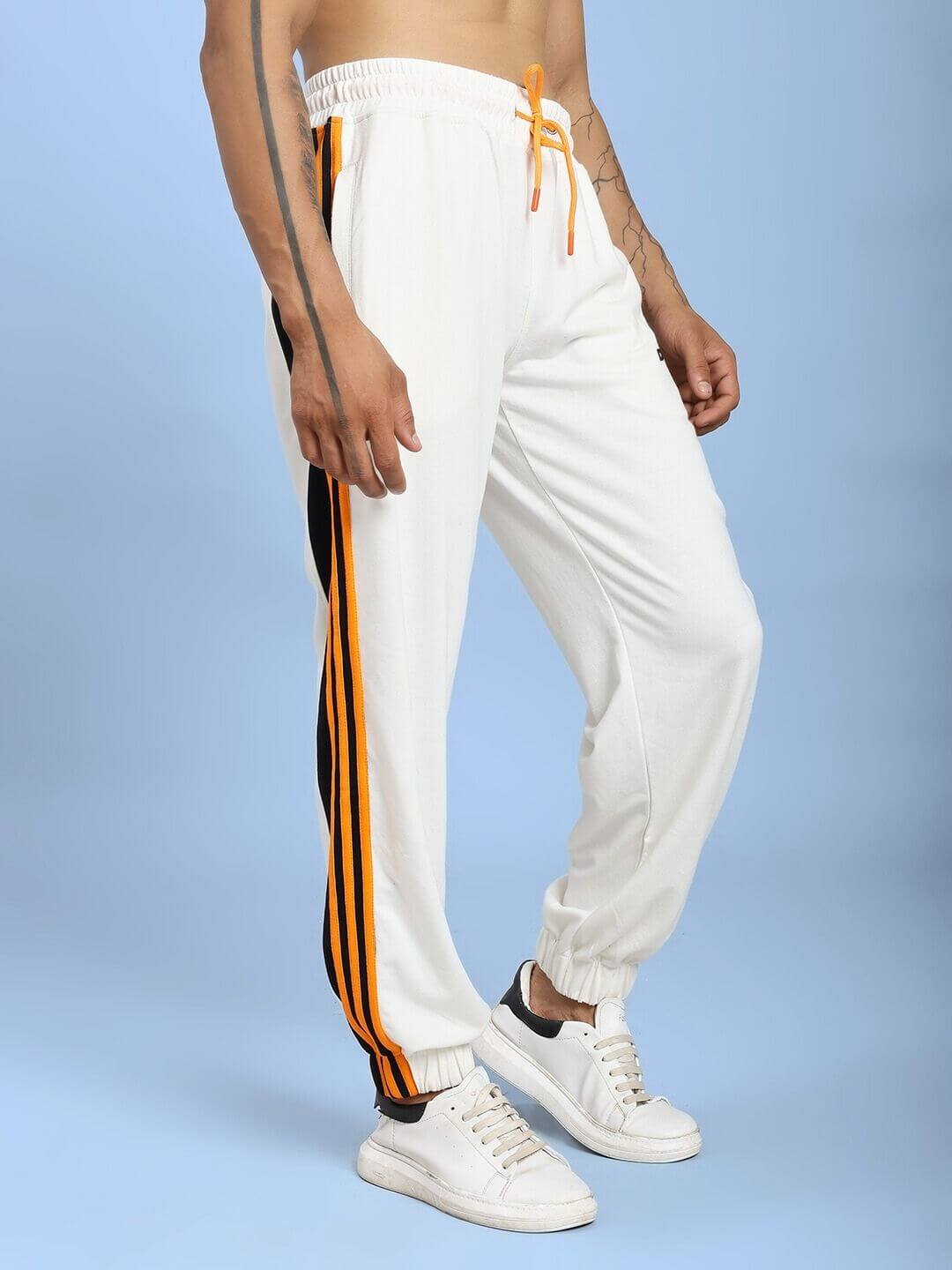 Person wearing COMFORT FLEX STRIPE JOGGER OFF-WHITE with side stripe, showcasing sleek and casual style.